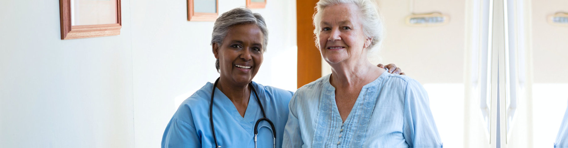 senior woman and caretaker smiling happily